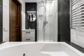 Bathroom with shower and large Jacuzzi bathtub with contrasting white and black walls Royalty Free Stock Photo