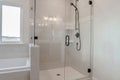 Bathroom shower stall with half glass enclosure adjacent to built in bathtub Royalty Free Stock Photo
