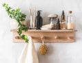 Bathroom simple interior - wooden shelf-hanger with accessories for care and beauty on a light background Royalty Free Stock Photo