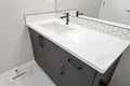 Bathroom sink with a dark cabinet and a white tile counter top Royalty Free Stock Photo