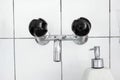 Bathroom sink and faucet with black mixing knobs and liquid soap dispenser. Close up shot, no people