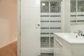 Bathroom with a square frameless mirror, a porcelain sink