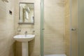 Bathroom,tiles and bright colors of broom, shower with frosted doors,mirror above the sink. Hanging a towel over the toilet on a h