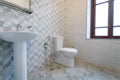 Bathroom, with tiles and bright colors of broom, shower with frosted doors,mirror above the sink.Hanging a towel over the toilet o