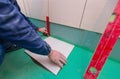 Bathroom tiles replacing. Caucasian worker is installing brand new ceramic tiles in bath is inder construction Royalty Free Stock Photo