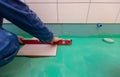 Bathroom tiles replacing. Caucasian worker is installing brand new ceramic tiles in bath is inder construction Royalty Free Stock Photo