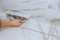 Worker grouting tiles with trowel cement mortar Royalty Free Stock Photo