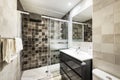 Bathroom with wall-mounted shower with marble tiles, square mirror