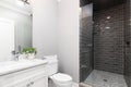 A bathroom with a white cabinet and a dark grey tiled shower. Royalty Free Stock Photo