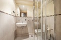 Bathroom with white porcelain hanging sink, square frameless mirror