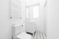 Bathroom with white porcelain sink, frameless mirror, chrome accessories,