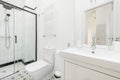 Bathroom with white porcelain sink, frameless mirror, chrome fixtures,