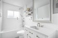 A bathroom with a white cabinet, cozy decorations, and herringbone tile shower. Royalty Free Stock Photo