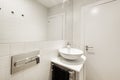 Bathroom with white wood cabinets, white porcelain hemispherical sink, large built-in mirror, tile work, and white wood door