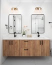 A bathroom with a wood cabinet, gold light fixtures, and marble countertop. Royalty Free Stock Photo