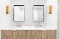 A bathroom with a wood cabinet, gold sconces, and tiled backsplash.