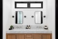 A bathroom with a wood cabinet and marble countertop. Royalty Free Stock Photo