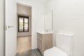 Bathroom with wooden cabinet with drawers, white porcelain sink, square frameless mirror, glass shower