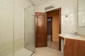 Bathroom with wooden furniture, glass shower cubicle and dark Royalty Free Stock Photo