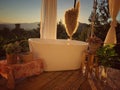 The bathtub in bathroom is surrounded by nature at sunset