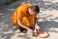 Monk feeding young dogs at Battambang on Cambodia