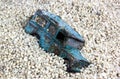 Battered Blue Toy Car in Sand Pit Against Blue Sky