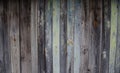 Battered, faded old vertical wooden planks of different widths with patches of knots and remnants of pastel green paint. Royalty Free Stock Photo