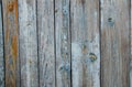 Battered, faded old vertical wooden planks with splotches of knots and remnants of light blue paint. Royalty Free Stock Photo