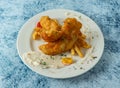 Battered Fish with french fries, lemon and dip served in plate isolated on background top view of italian food Royalty Free Stock Photo