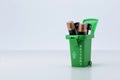 Batteries in green trash bin on white grey background Royalty Free Stock Photo