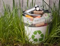 battery recycle bin with old element on wood table in grass