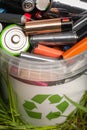 Battery recycle bin with old element on wood table in grass