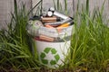 Battery recycle bin with old element on wood table in grass