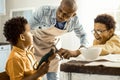 Father asking boys to stop playing at the table. Royalty Free Stock Photo