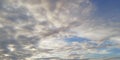 The battle of light and darkness. Light white clouds and dark clouds in the blue sky. Interesting unusual background