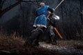 The battle between medieval knights in the style of Game of Thrones in winter forest landscapes. Spear against sword