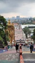 Back view from golden statue Ganesha with view through long way stairs and corporate buildings from the city in background