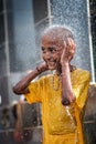 Close-up of young boy devotee having shower ritual in Thaipusam Festival.