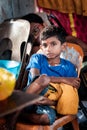 Close-up of young boy devotee sitting on the chair in Thaipusam Festival