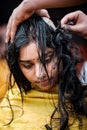 Close-up of young lady devotee getting tonsured or head shaving ritual in Thaipusam Festival.