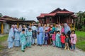 Batu Pahat, Malaysia - May 3rd, 2022 : Happy Malay family in traditional clothing and traditional Malay house during Hari Raya.