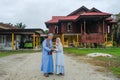 Batu Pahat, Malaysia - May 3rd, 2022 : Happy Malay family in traditional clothing and traditional Malay house during Hari Raya.