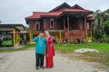 Batu Pahat, Malaysia - May 3rd, 2022 : Happy Malay family in traditional clothing and traditional Malay house during Hari Raya.