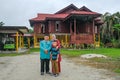 Batu Pahat, Malaysia - May 3rd, 2022 : Happy Malay family in traditional clothing and traditional Malay house during Hari Raya.