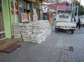 Bags of building material stacked on top of each other against the wall. Store goods on the street. Market Street. Bags of