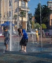 Boy is playing in the fountain. Wet child in the fountain. Splashes of water on a person. Wet clothes on the guy Royalty Free Stock Photo