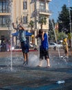 Boys is playing in the fountain. Wet child in the fountain. Splashes of water on a person.