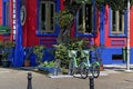 BATUMI, GEORGIA - JUNE 29, 2023: Green rental bicycles parked in front of a vibrant blue and red building with a tree in Batumi