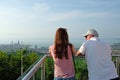 A young girl with an elderly man stands and admires the panorama of the city.