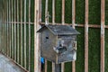 A metal mail box with a Georgian cross on the roof is attached to a metal fence on the street of Batumi city - the capital of